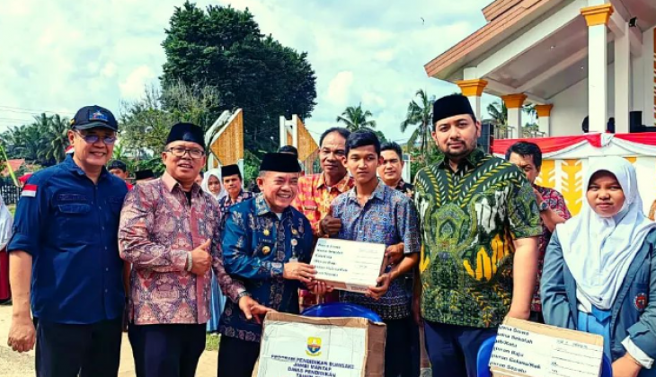 Gubernur di dampingi Kepala Dinas Pendidikan Provinsi Jambi Menyerahkan Bantuan Program Pendidikan Dua Miliar Satu Kecamatan (Dumisake) pada 4.701 siswa SMK, SMA dan SLB di Provinsi Jambi